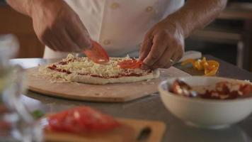 el chef agrega ingredientes a la pizza video