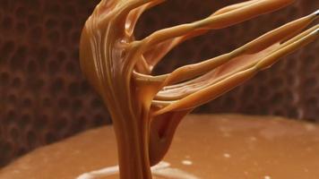 Melted caramel dripping from whisk, closeup food shot. video
