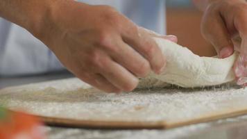 gros plan des mains préparant la pâte à pizza fraîche video