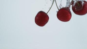 tir au ralenti de cerises éclaboussant dans l'eau, tourné avec une caméra fantôme flex 4k. video