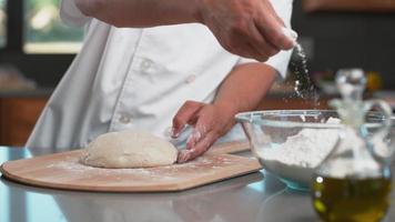 Chef sprinkles flour onto dough in super slow motion, shot with Phantom Flex 4K camera.