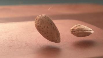 Almonds falling onto wooden surface in super slow motion.  Shot on Phantom Flex 4K high speed camera. video