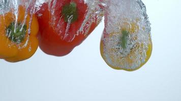 Bell peppers splashing into water in slow motion shot on Phantom Flex 4K at 1000 fps video