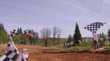 Motocross racers going over big jump in slow motion 4K fully released video