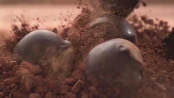 trufas de chocolate caindo em pó de chocolate em super câmera lenta. filmado em câmera de alta velocidade phantom flex 4k. video