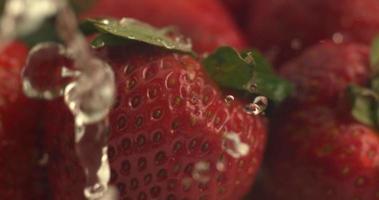 Wasser tropft in Superzeitlupe auf Erdbeeren. Aufgenommen mit Phantom Flex 4k Hochgeschwindigkeitskamera. video