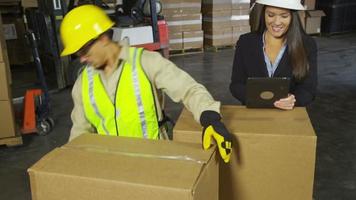 Workers using digital tablet in shipping warehouse video