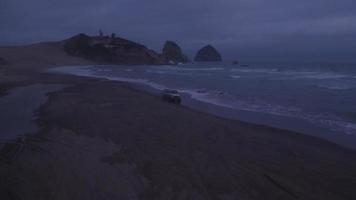 Aerial view of group of friends driving on beach in vintage vehicle video