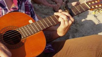 Close up of young person playing acoustic guitar video