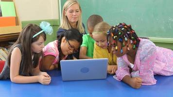 professor e alunos trabalham no laptop na sala de aula da escola video