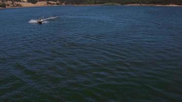 Aerial drone shot of man riding personal water craft on lake video