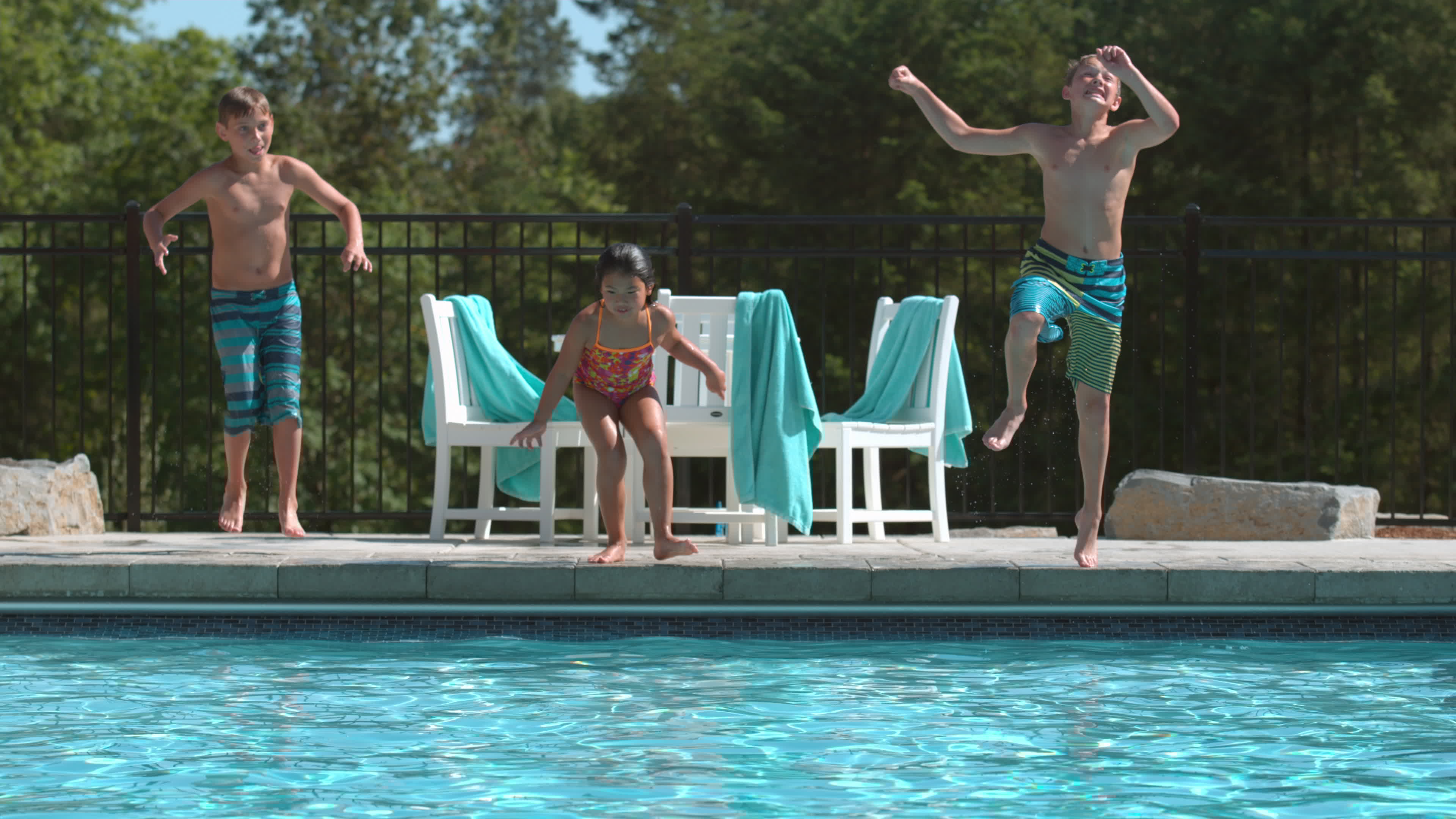 Three kids jumping into pool in super slow motion 2574712 Stock Video