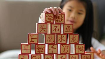 niña apilando bloques chinos video