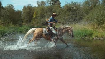 Mujer montando a caballo a través del arroyo en cámara super lenta, filmada en el fantasma flex 4k a 1000 fps video