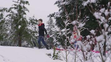 barn som går genom snö med slädar på vintern video