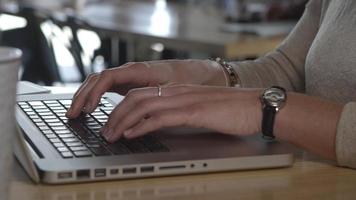 close-up de mulher de negócios digitando no teclado do laptop em um espaço de trabalho casual video