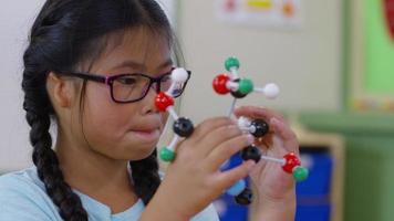 garota na sala de aula brincando com modelo de ciências video