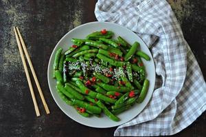 Green pea pods with chilli and sesame photo