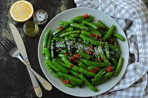 Green pea pods with chilli and sesame photo