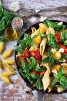 Pasta in a pan with tomatoes basil and spices photo