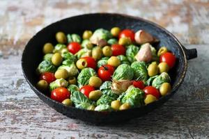 Brussel sprouts with vegetables and herbs in a pan photo