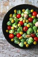 Brussel sprouts with vegetables and herbs in a pan photo