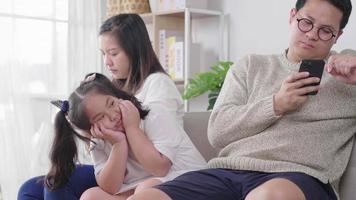 familia sentada en el sofá juntos en la sala de estar padre ignorando a un niño al estar en el teléfono inteligente jugando y comprando en línea sin preocuparse por un niño aburrido video