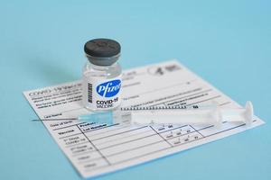 United States, 2021 - Close up image of a Pfizer vaccine vial and syringe with vaccine card