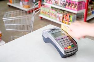 Hand swiping credit card on payment terminal in store photo