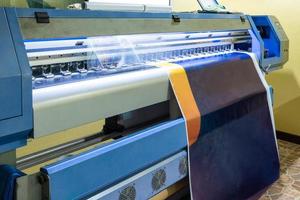 Gran cabezal de impresora de inyección de tinta trabajando en banner de vinilo azul