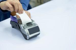 Staff cashier rip bill paper with card on payment terminal photo