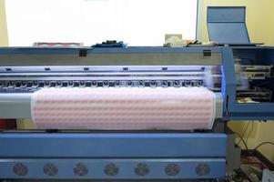 Impresora de inyección de tinta de gran formato que trabaja en hojas de pegatinas con la marca. foto