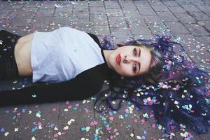 Beautiful young woman surrounded by confetti photo