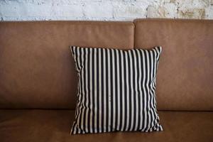 almohada blanca en el sofá de cuero marrón foto