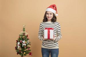 Hermosa niña de Navidad con gorro de Papá Noel con cajas sobre fondo de otoño foto