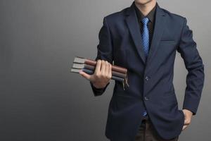 Close up of businessman in blue suit holding books on gray background photo