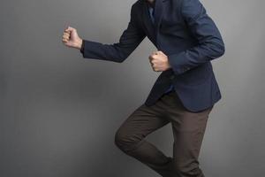 Close up of businessman in blue suit Fighting on gray background photo