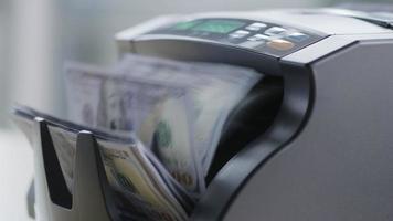 closeup tiro de máquina de contagem de dinheiro com notas de 100 dólares. video