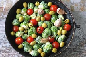 Brussel sprouts with vegetables and herbs in a pan photo