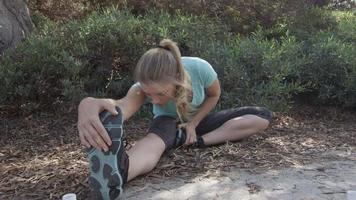A young woman runner stretching before her run video