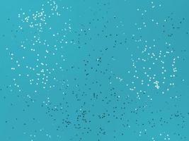 estrellas de confeti brillando sobre un fondo azul. foto