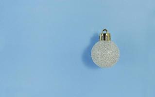 bola del árbol de navidad en un papel azul. plano simple con espacio de copia. foto
