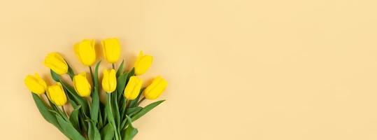 ramo de tulipanes amarillos sobre fondo beige con espacio de copia. foto