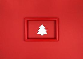 Red frame, with white wood Christmas tree toy inside. photo