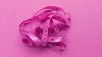 centímetro rosa sobre fondo rosa. plano simple con textura pastel. concepto de fitness. foto de stock.