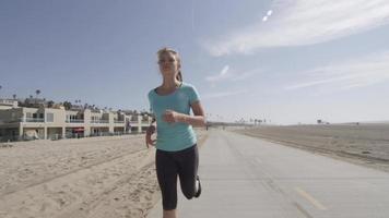 een vrouwelijke hardloper die gaat hardlopen op het strand. video