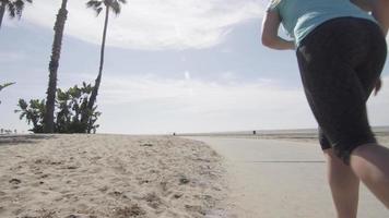 una donna runner che va a correre sulla spiaggia.