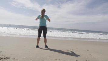 un corridore donna che riposa sulla spiaggia dopo la sua corsa. video