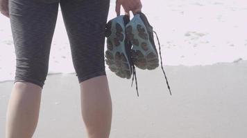 een vrouwelijke hardloper die na haar run op het strand rust.