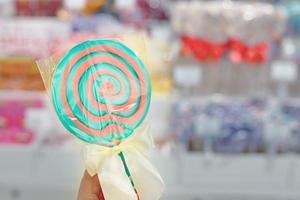 Lollipop with stick on background of shop window. photo
